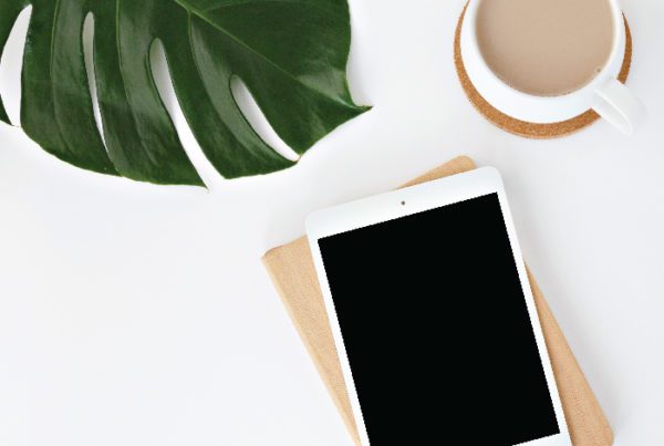 iPad and coffee cup on white table