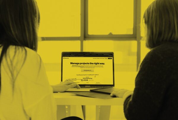 Basecamp branding on laptop screen and people collaborating
