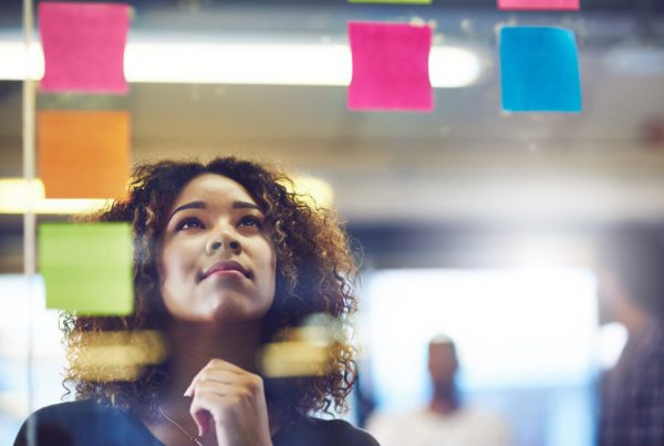 Woman looking at sticky notes on kanban board