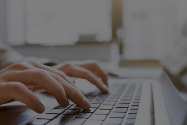 Fingers typing on laptop keyboard