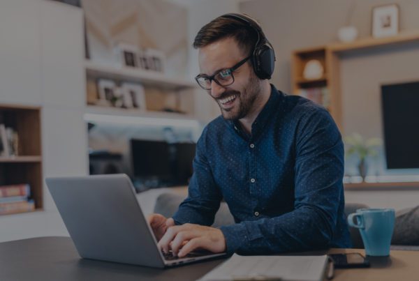 Man smiling while working on his laptop