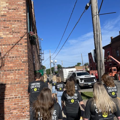 TwoTone Creative team walking together, celebrating company history and support system.