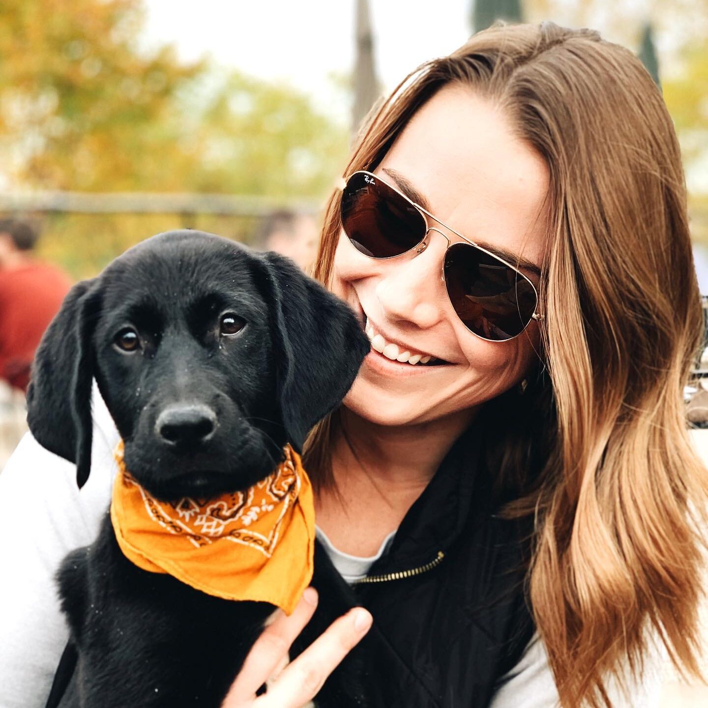 Emily Field and black labrador puppy wearing orange bandana, reflecting TwoTone Creative culture.
