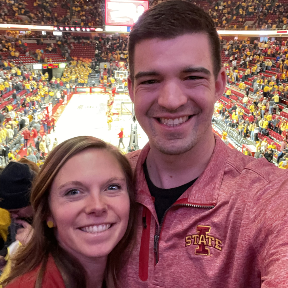 Aaron Hewitt and colleague smiling at Iowa State basketball game, TwoTone Creative team.
