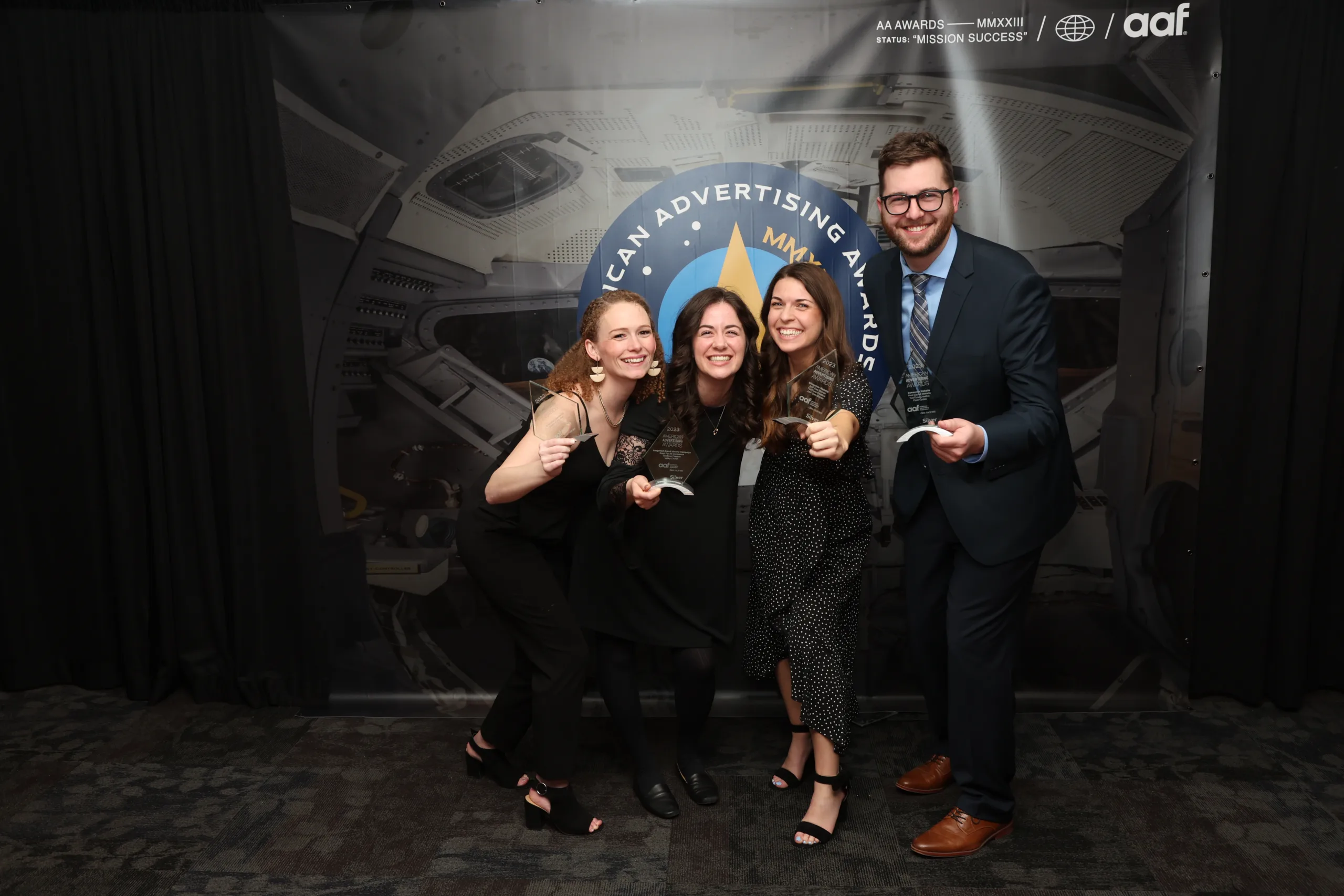 TwoTone Creative team celebrating American Advertising Awards with trophy and backdrop.