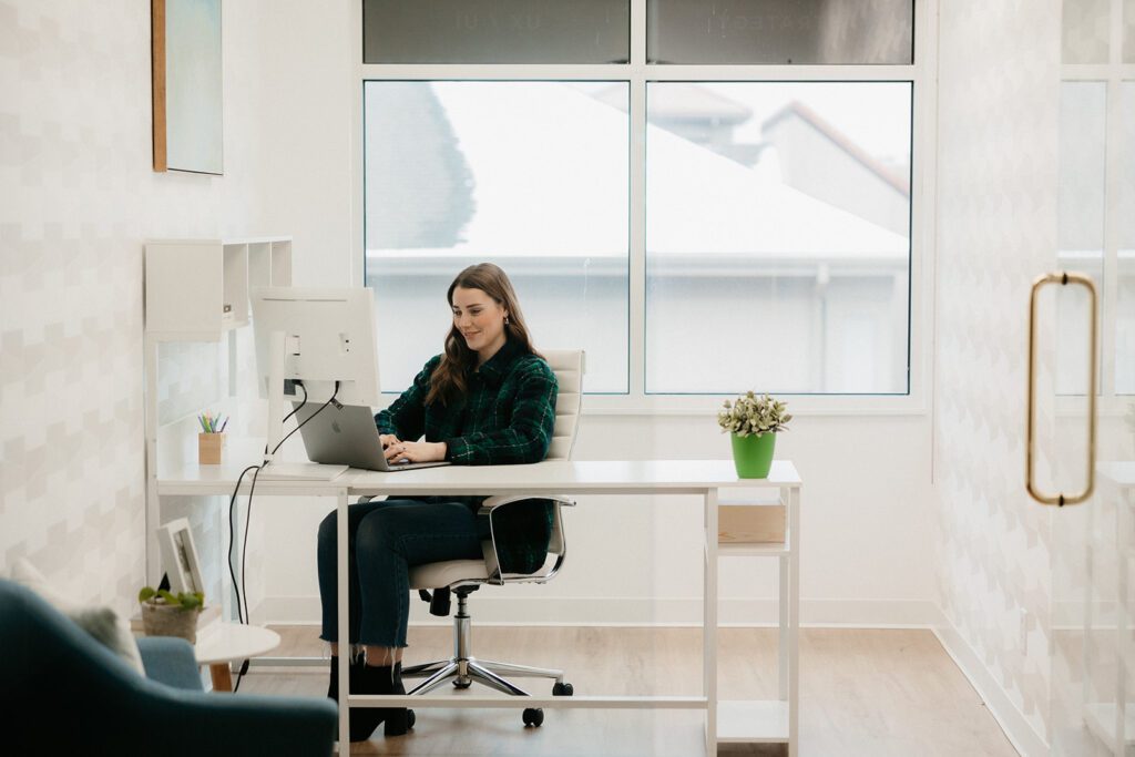 Woman working at desk in modern office space, TwoTone Creative marketing agency.