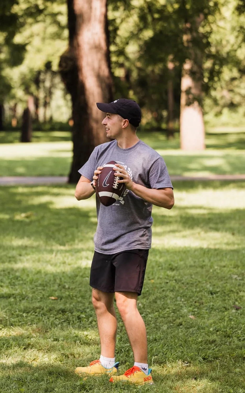 TwoTone Creative team member playing football in the park during Vision Day celebration.