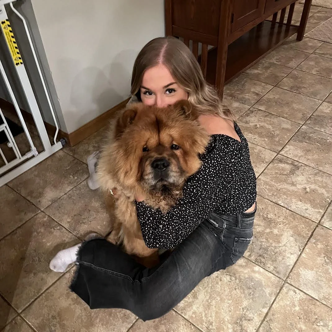 Kate Kohart hugging her fluffy Chow Chow dog, reflecting personal interests and social media expertise.