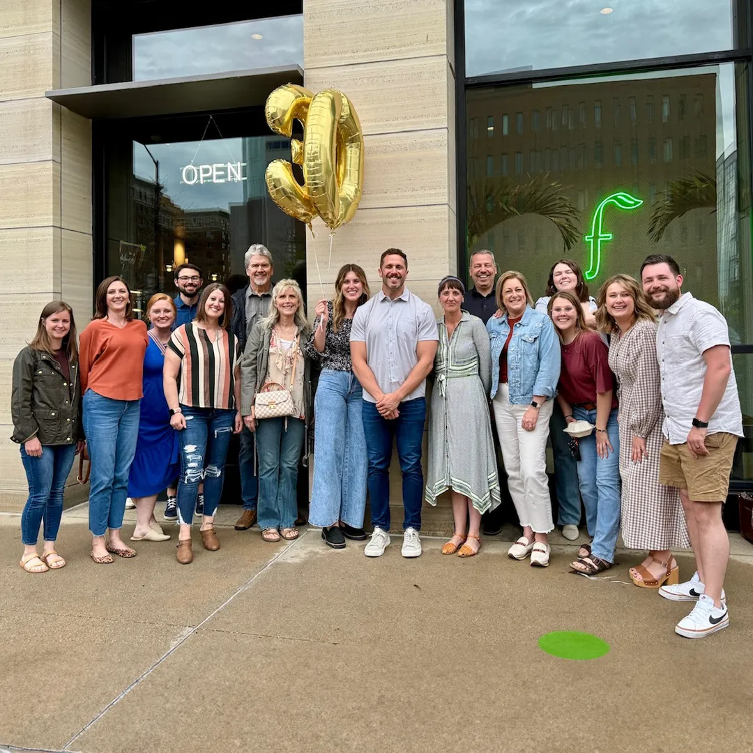 TwoTone Creative team celebrating with "OPEN" balloon and company logo.
