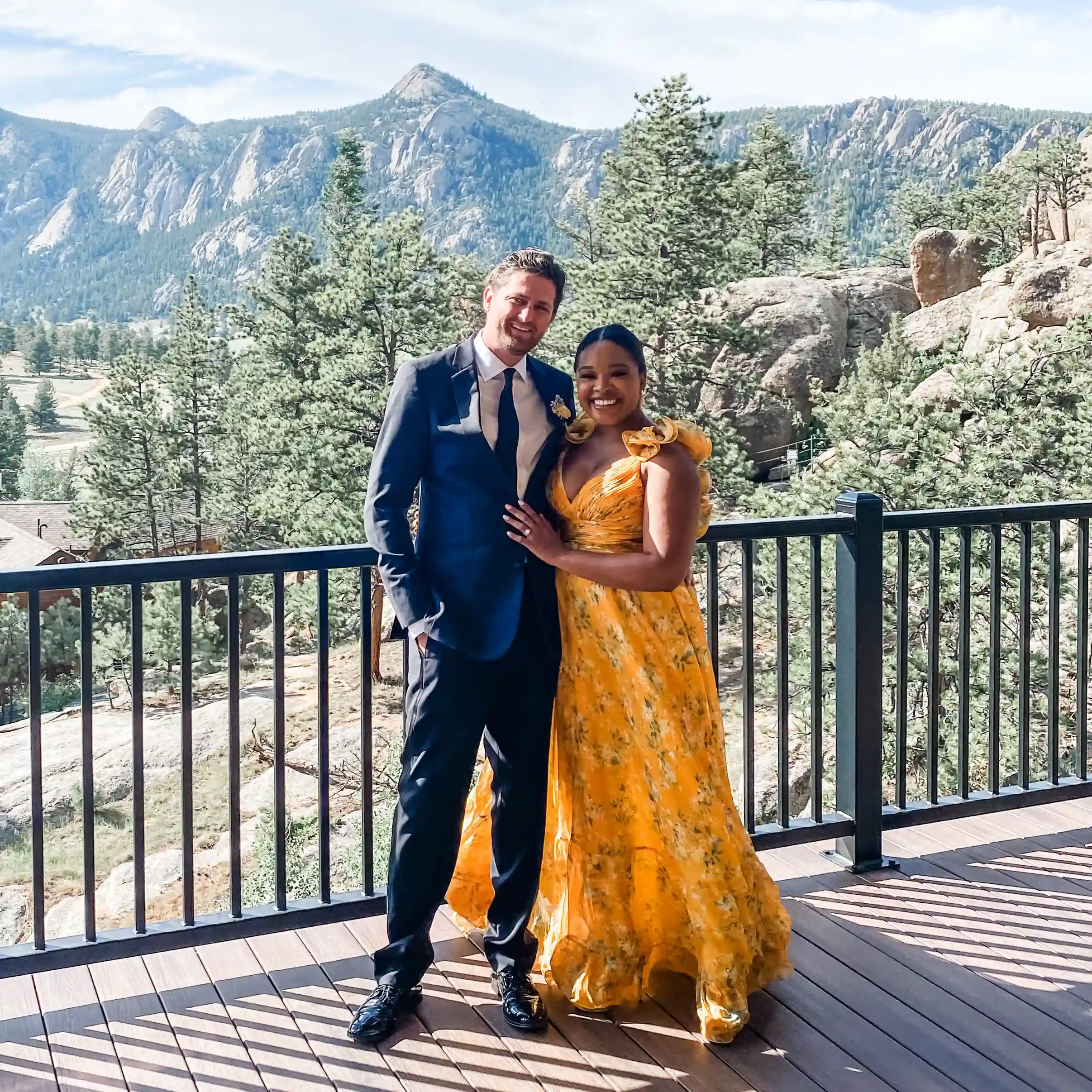 Ashlhea Demianovich and a colleague smiling and posing in formal wear with mountain backdrop.