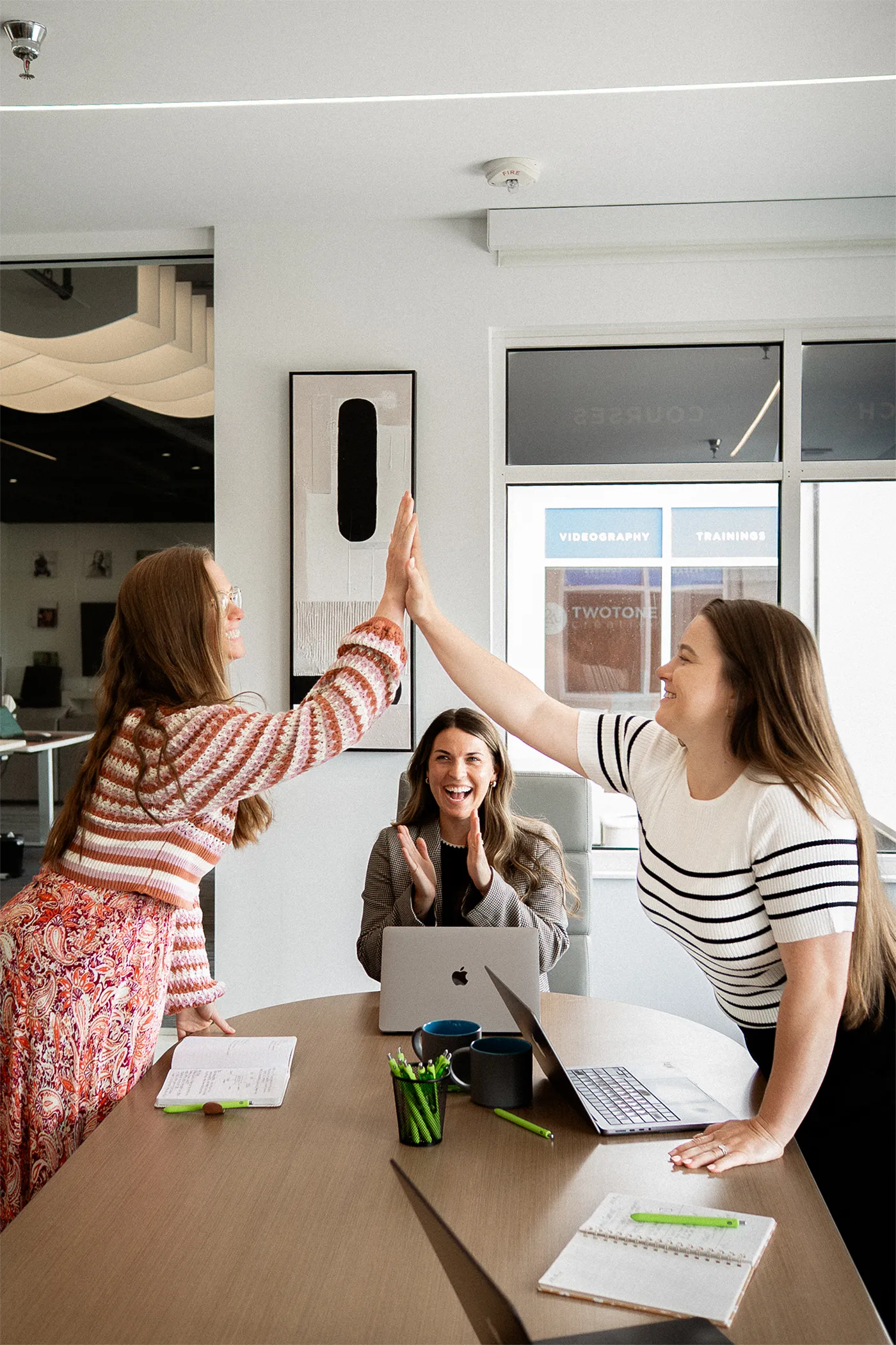 TwoTone Creative team celebrating success and collaboration in a modern office environment.