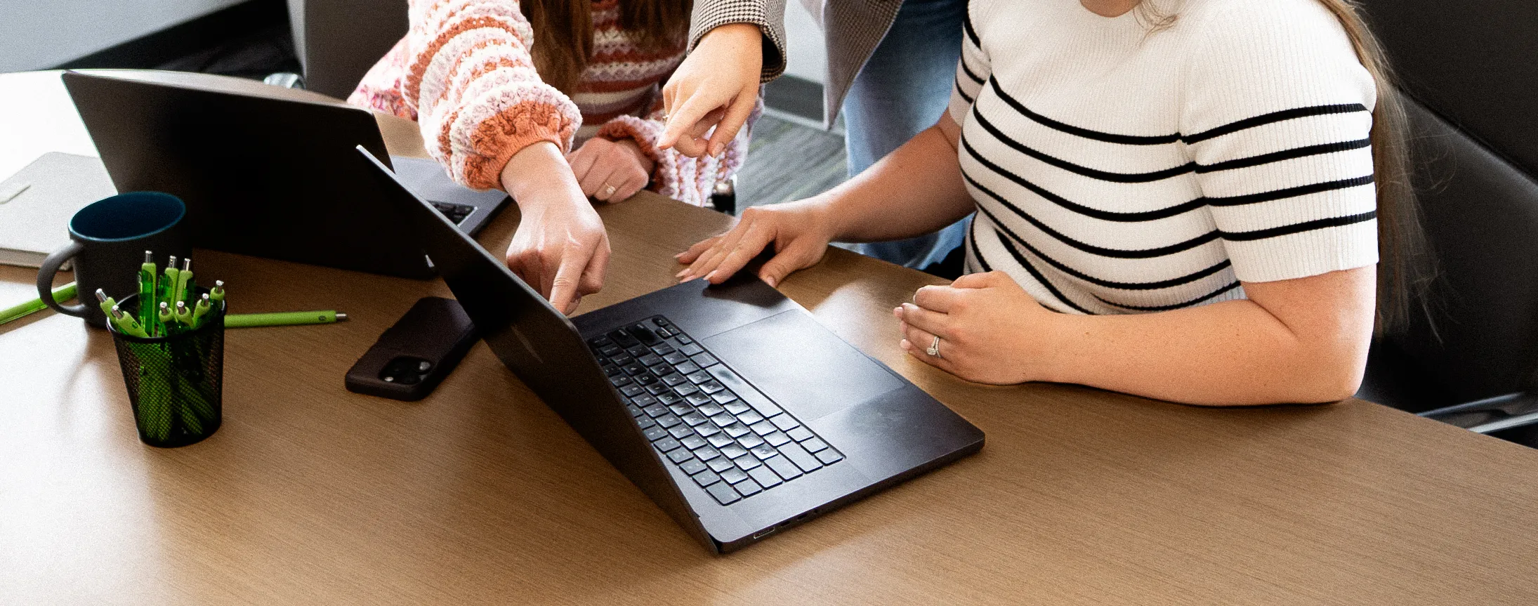 TwoTone Creative marketing team collaborating on laptop for website design and branding insights.